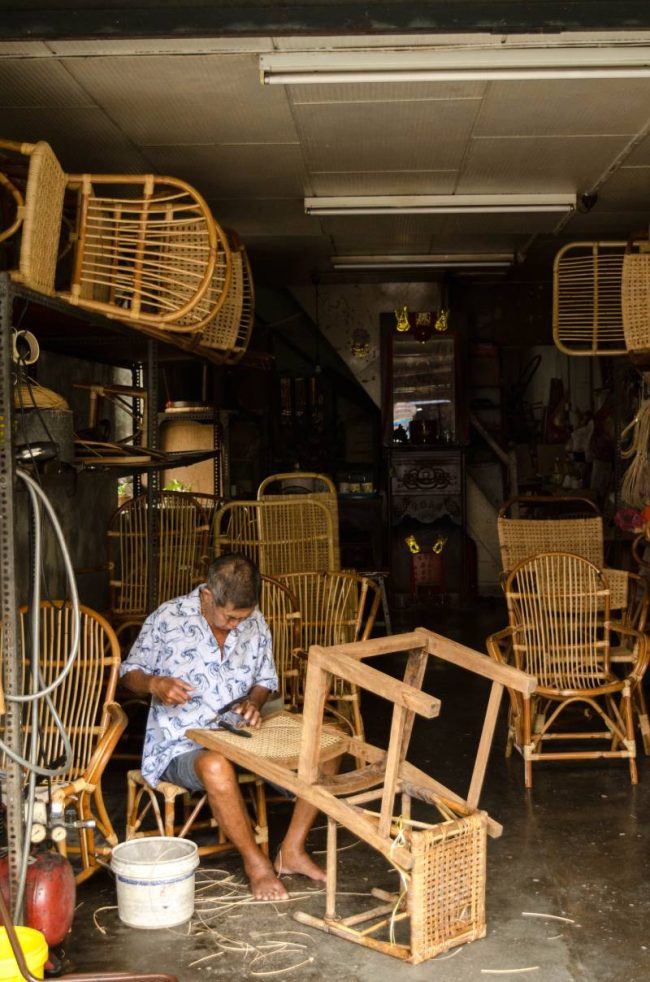 Older man making wooden chairs in a store in george town, penang, malaysia